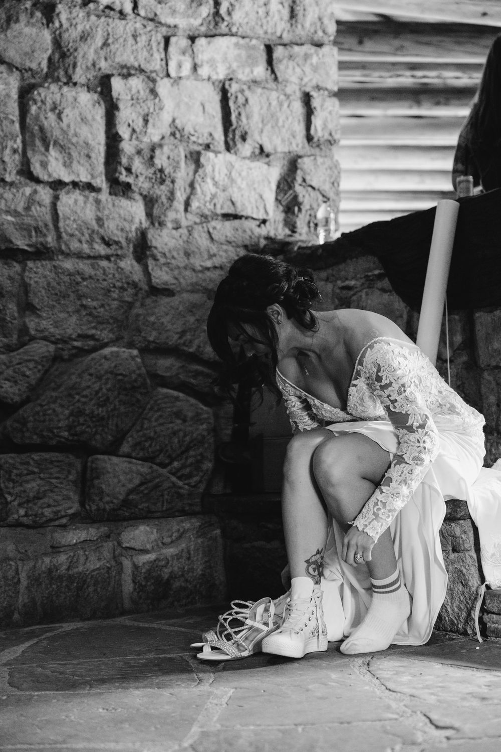 A sequence of black and white photos showing someone lying down and peeking under a stone wall in a playful manner.