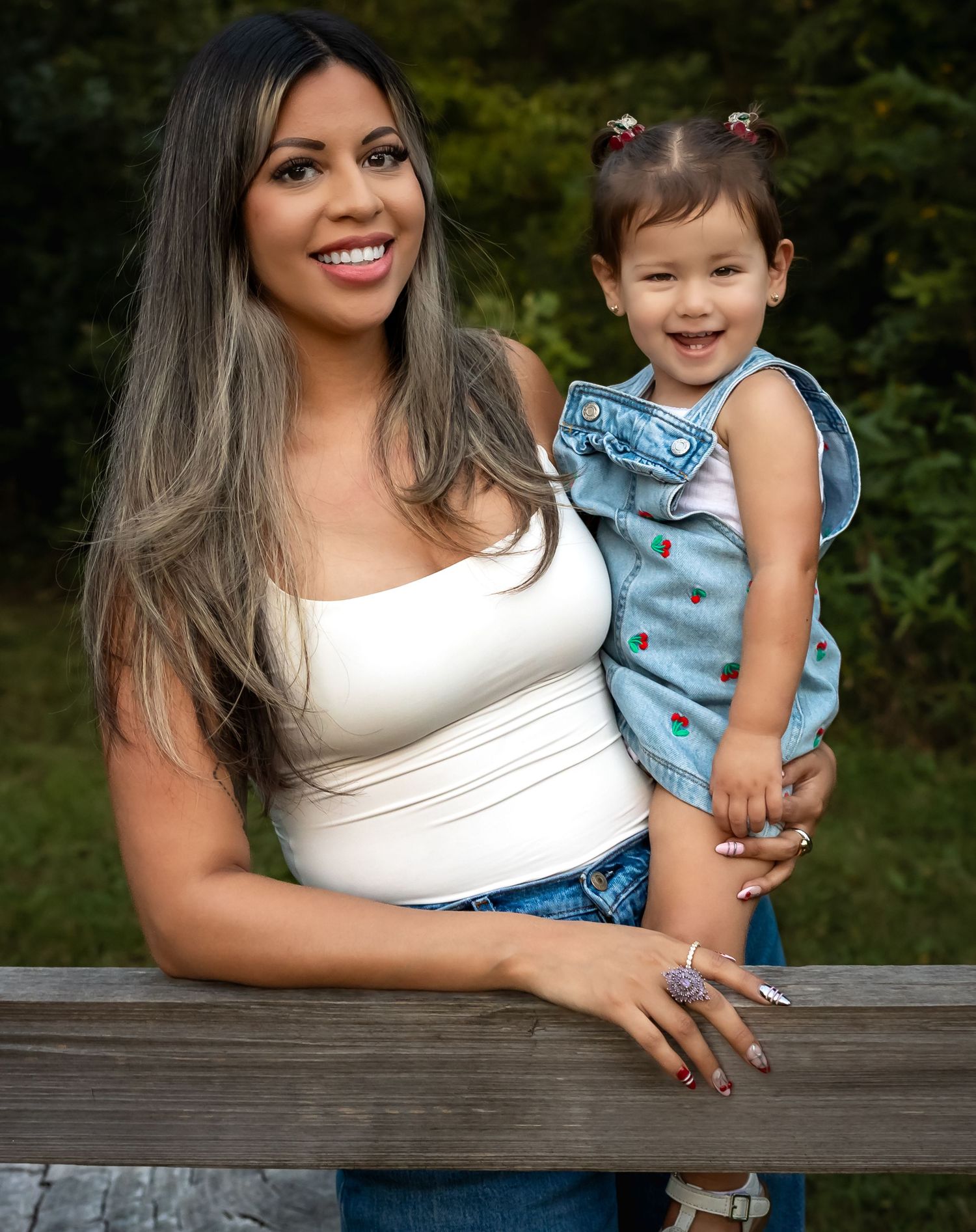 Mother and child sharing joyful moments together on a wooden deck outdoors.