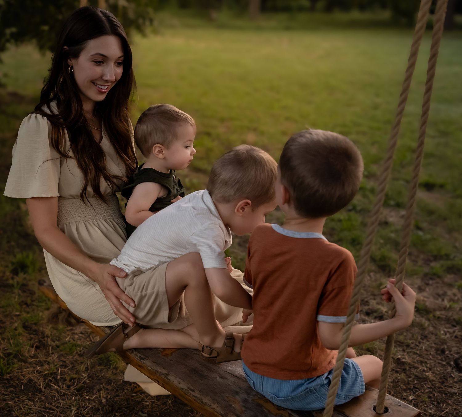 Family members sharing playful moments on outdoor swing in natural setting.