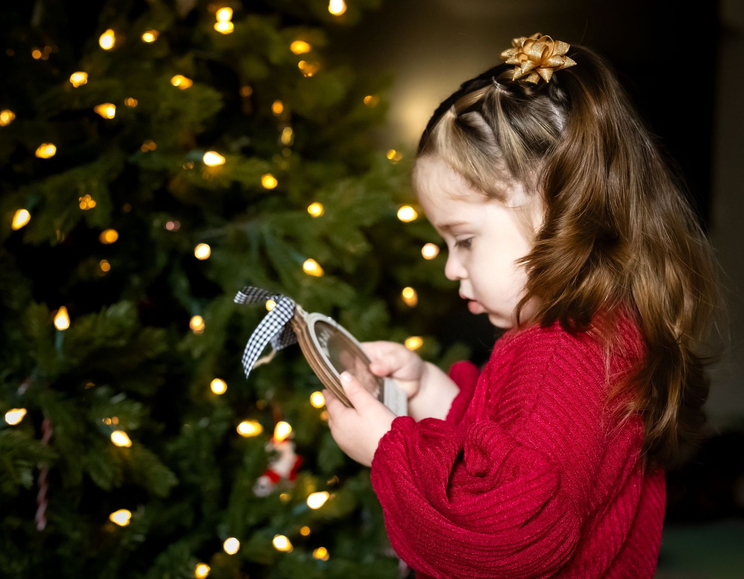 A sequence of photos shows someone in red clothing taking a picture near a Christmas tree with twinkling lights.