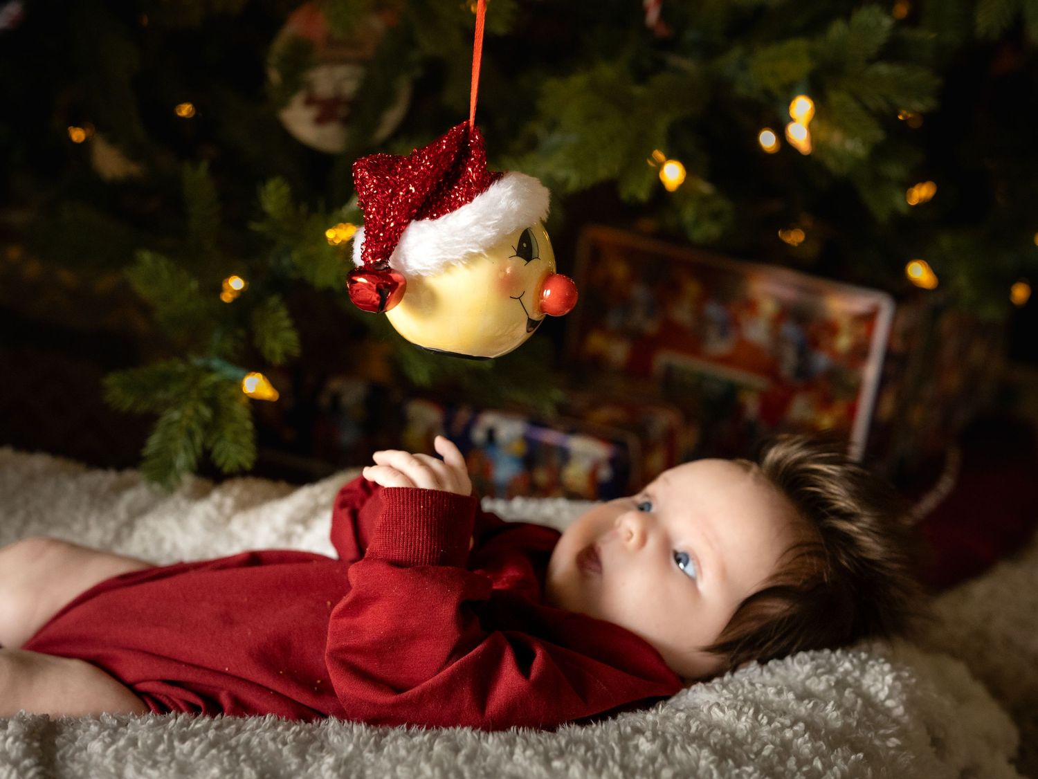 A festive Christmas photo series shows a sleeping figure in red clothing next to holiday decorations and twinkling lights.