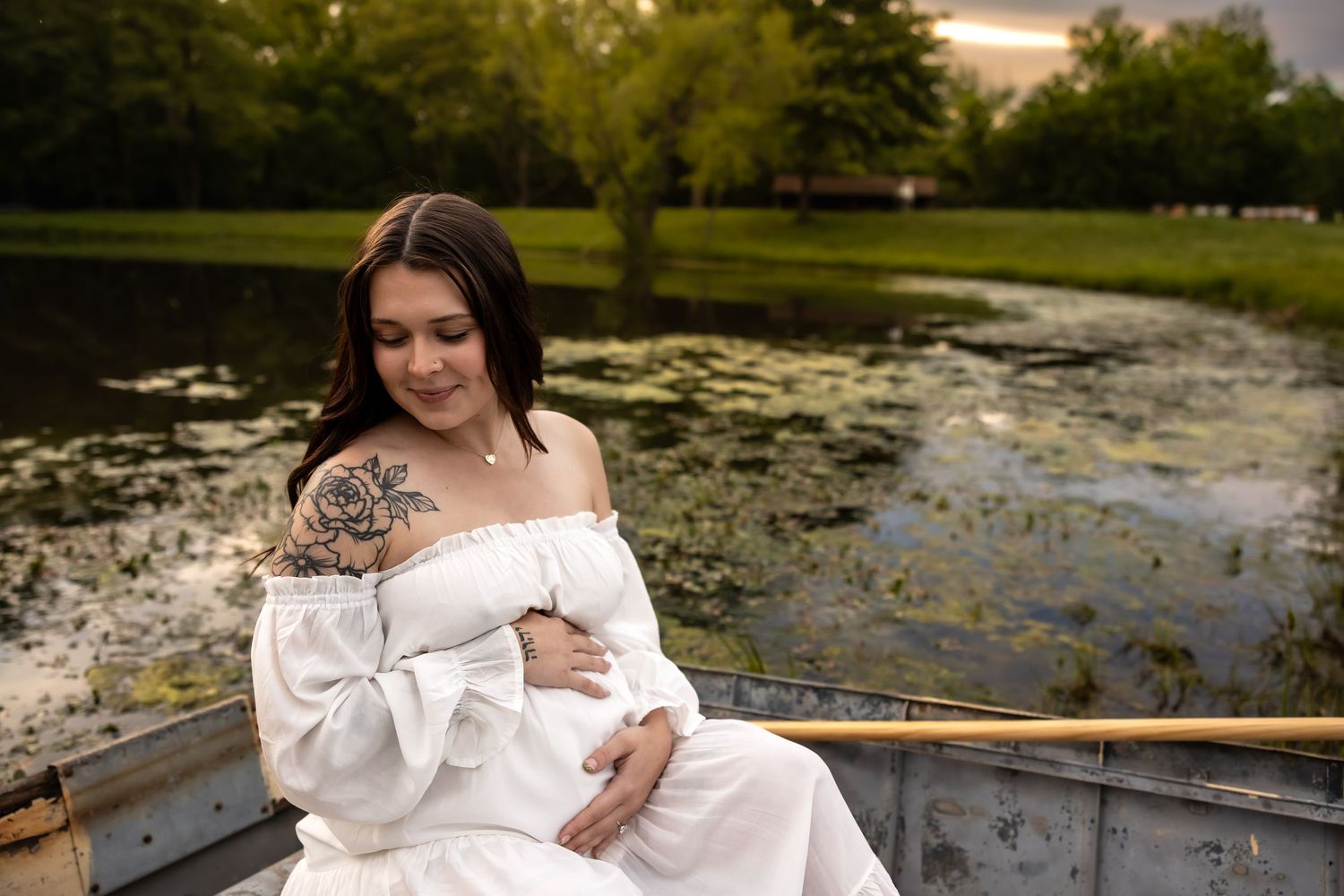 Romantic boat scene with white dress flowing over wooden planks at sunset.