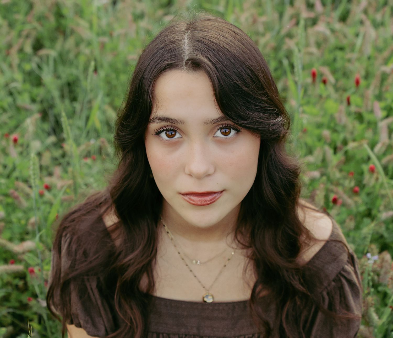 Senior portrait series showing different expressions against a natural green background.