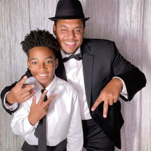 Black and white formal photo booth strip showing people in suits making fun poses.