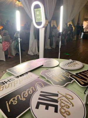 Illuminated ring lights and decorative signage at an evening event.
