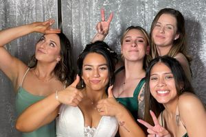 Group posing together in a photo booth with party accessories and props.