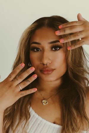 Close-up beauty shot with manicured nails and jewelry details.
