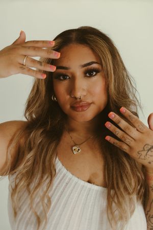 Beauty portrait featuring manicured hands and delicate jewelry details.