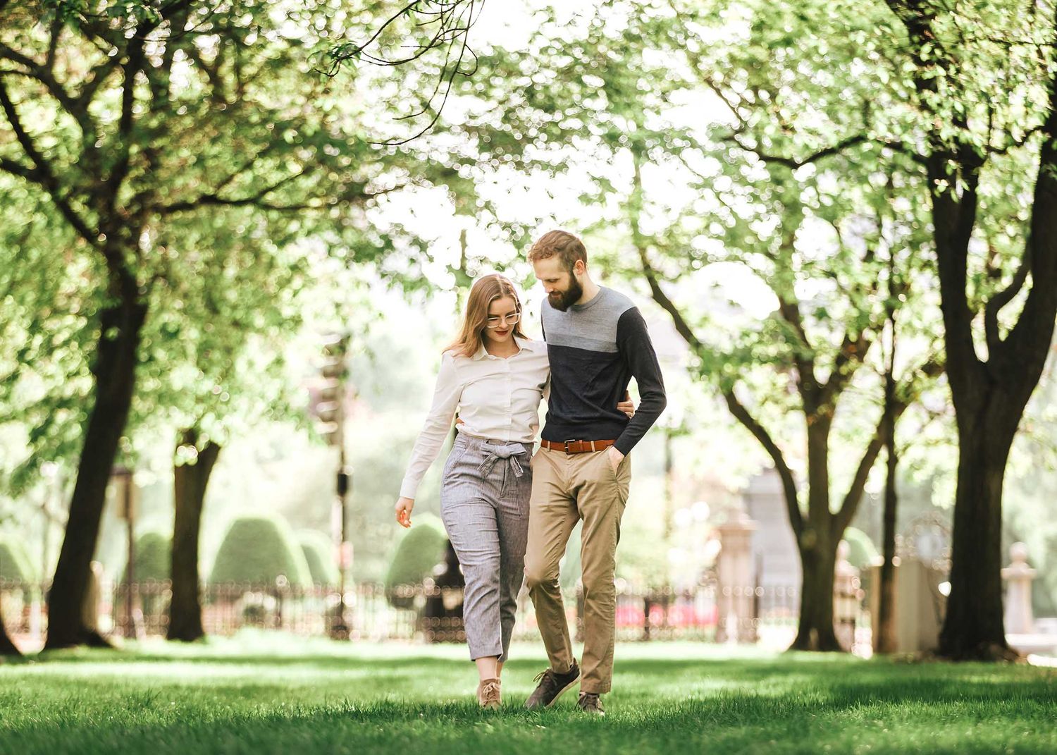 Engaged couple strolling hand in hand through the tree-lined Commonwealth Avenue Mall during an early morning Boston engagement session