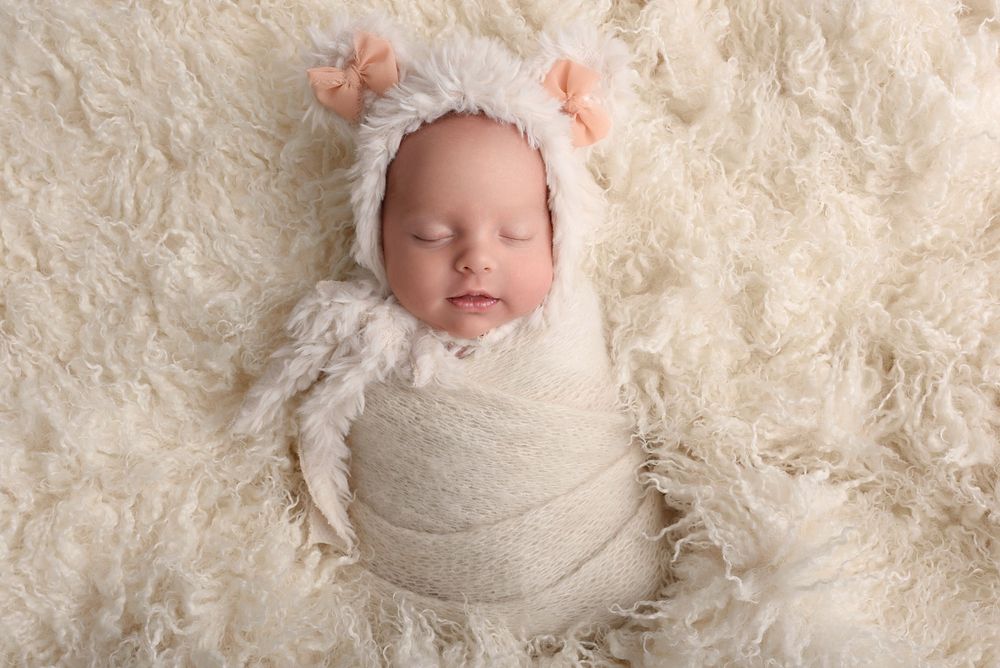 Series of newborn portraits on cream textured blanket showing peaceful sleeping poses.