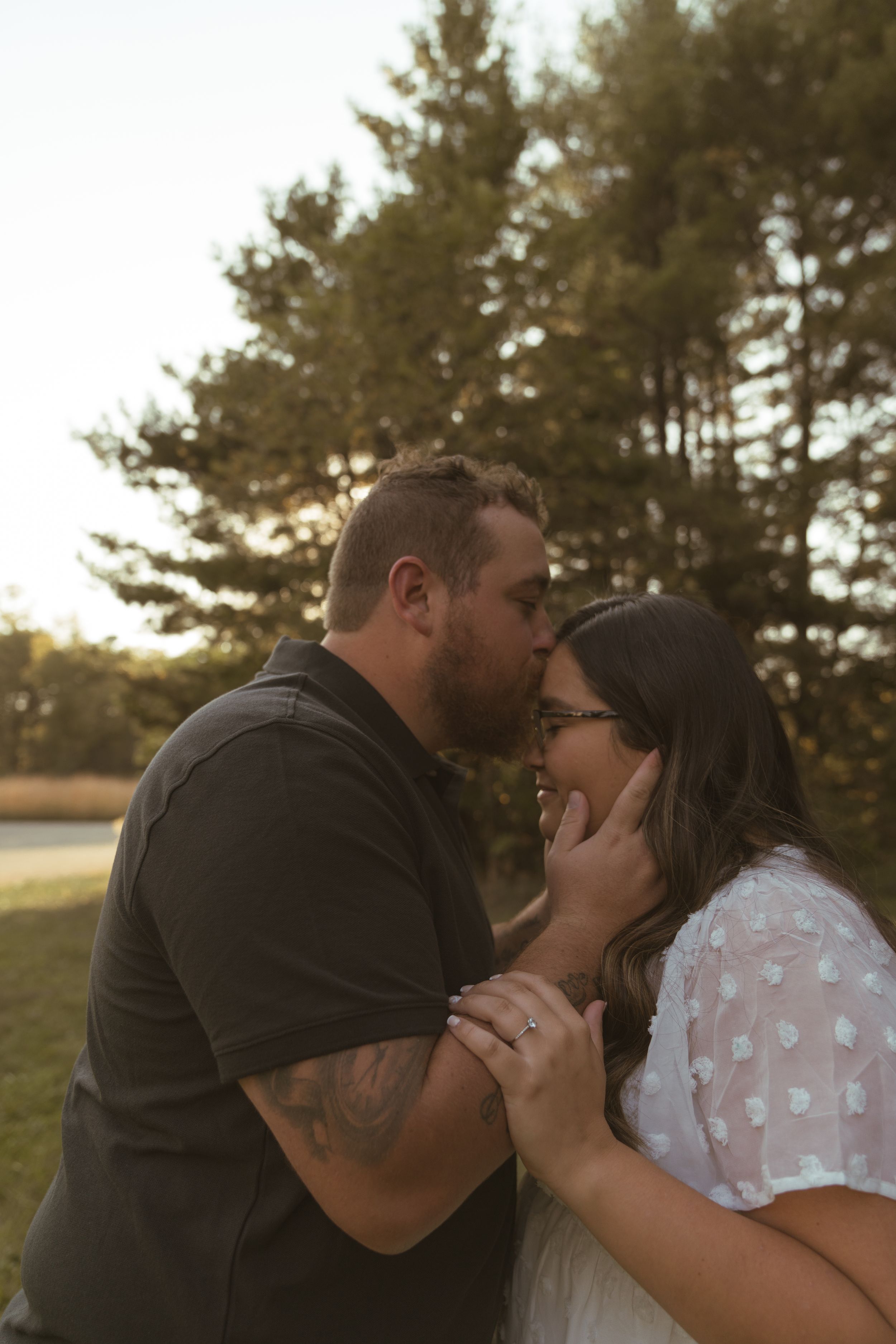 An intimate moment between a couple during their sunset engagement session.