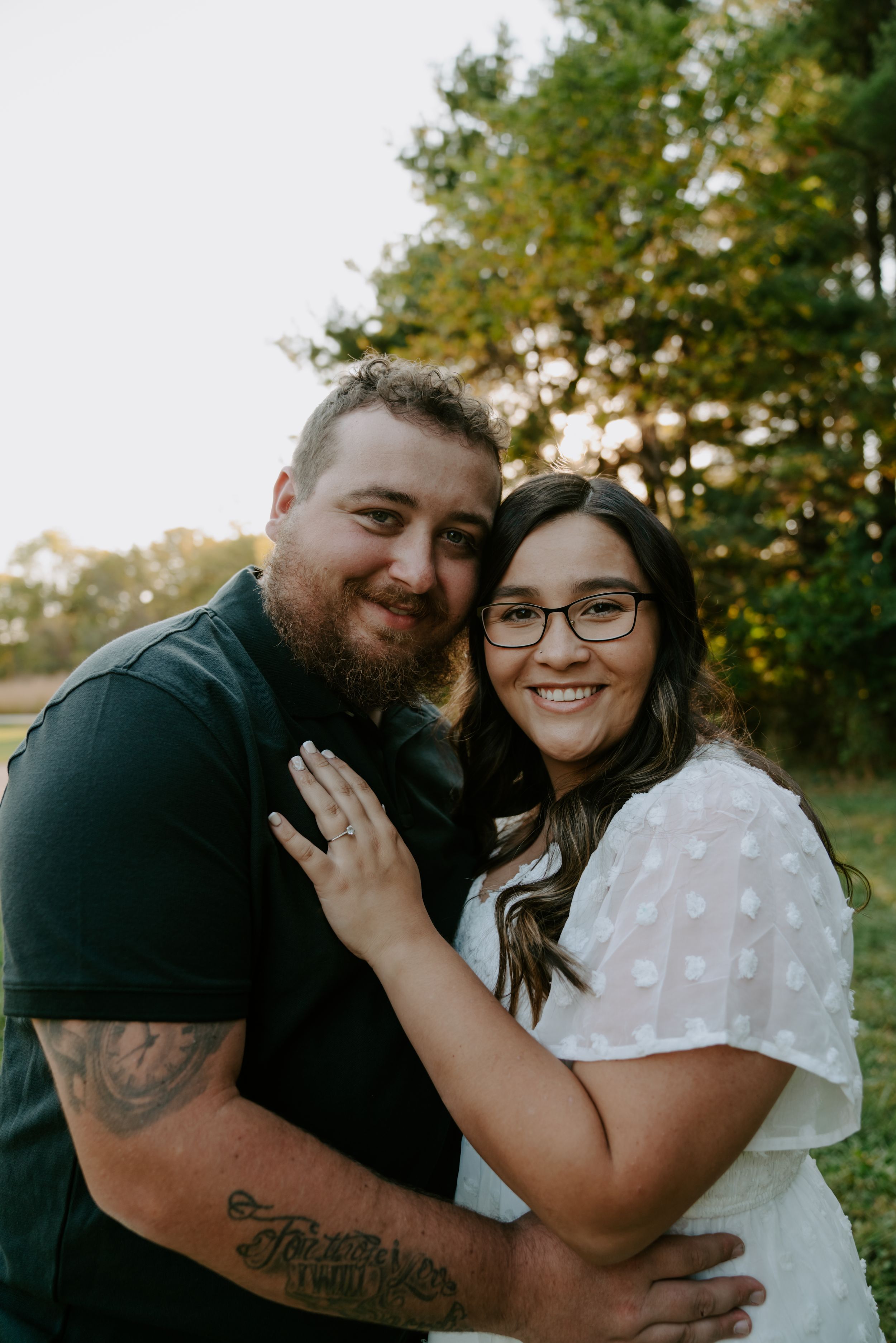 A joyful couple shares loving embraces during their outdoor engagement photo session.