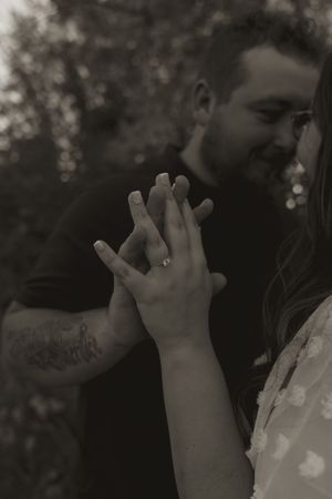 Close-up shot of hands intertwined during an intimate outdoor moment.