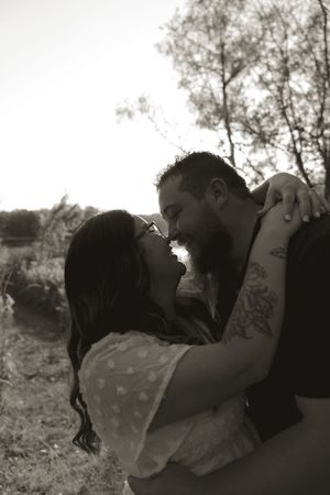 Black and white intimate portrait of a couple in an outdoor setting.
