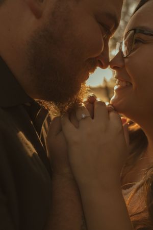Close-up shot of couple in tender moment with warm sunset lighting.