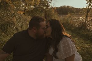 Couple enjoying intimate moment together in scenic outdoor fall setting.