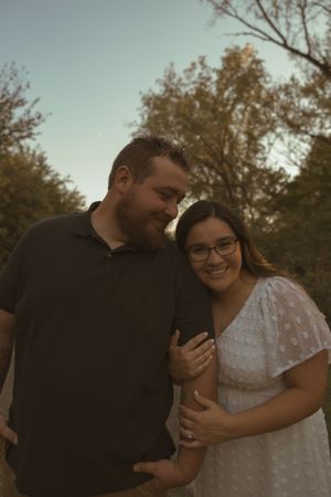 A romantic couple embraces in a tender moment against an autumn backdrop.