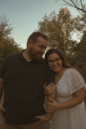 A couple shares a joyful laugh while embracing outdoors.