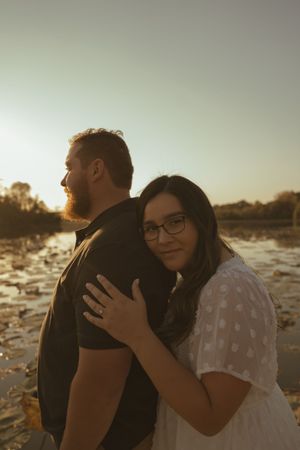 A tender embrace captured during sunset by the water.