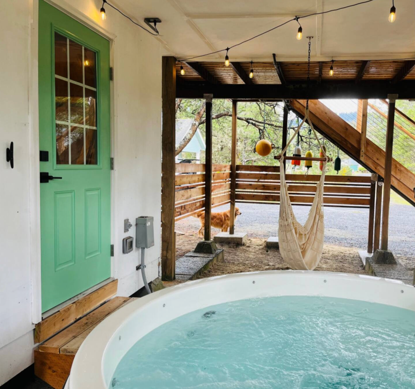 Indoor swimming pool with turquoise water surrounded by wooden beams and large windows in a spa-like setting.