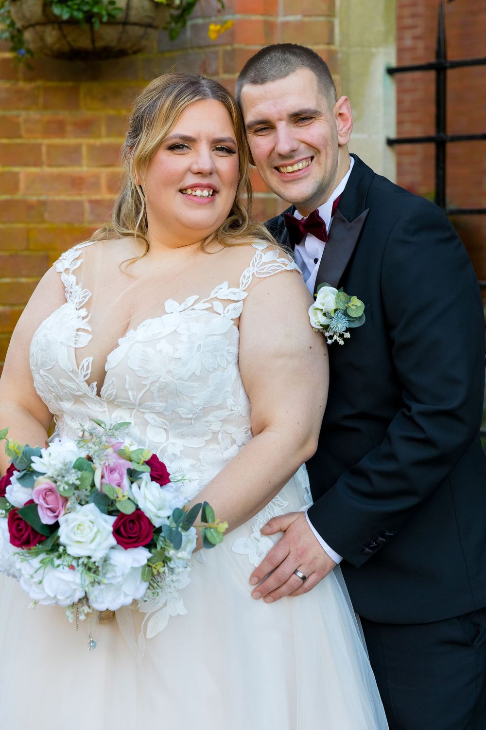 Bride and groom smiling together at the front of Audleys Wood Hotel