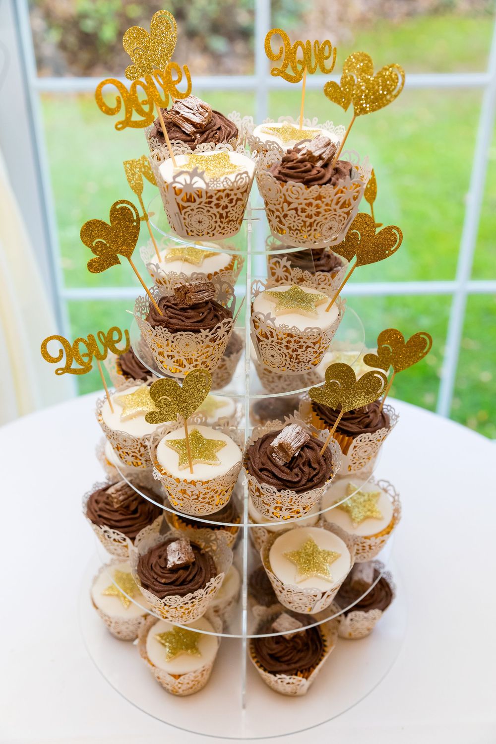 Cupcake tower decorated with gold glitter hearts and stars, perfect for Katie and Ben’s November wedding.