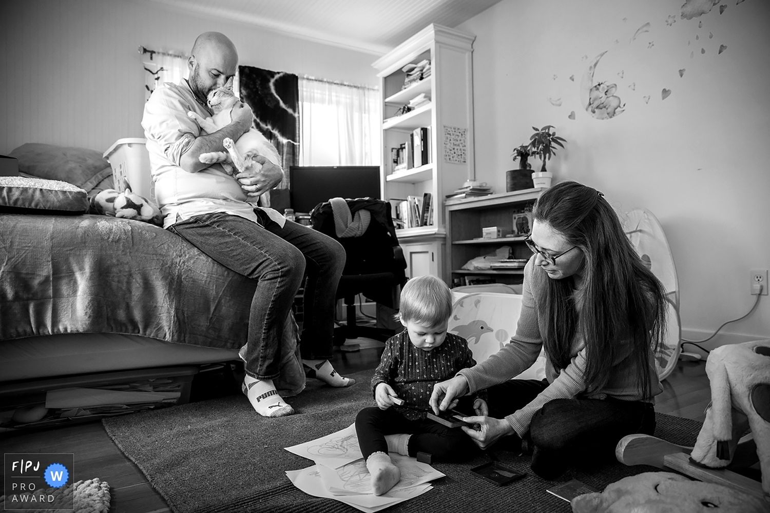 Family lifestyle WPJA FPJA award winning image mom and child painting while dad hugs the cat