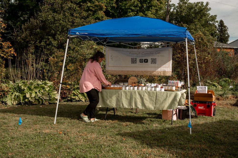 Blue canopy tent set up with display table at an outdoor market.