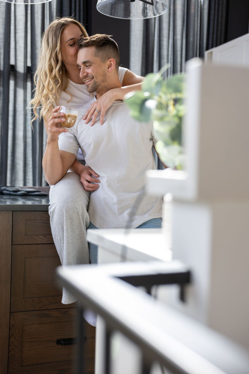 Romantic couple in white sharing an intimate moment in a bright modern interior space.
