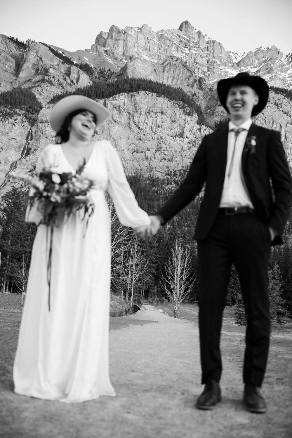 A playful wedding photo sequence showing a couple dancing and twirling against a mountainous backdrop.