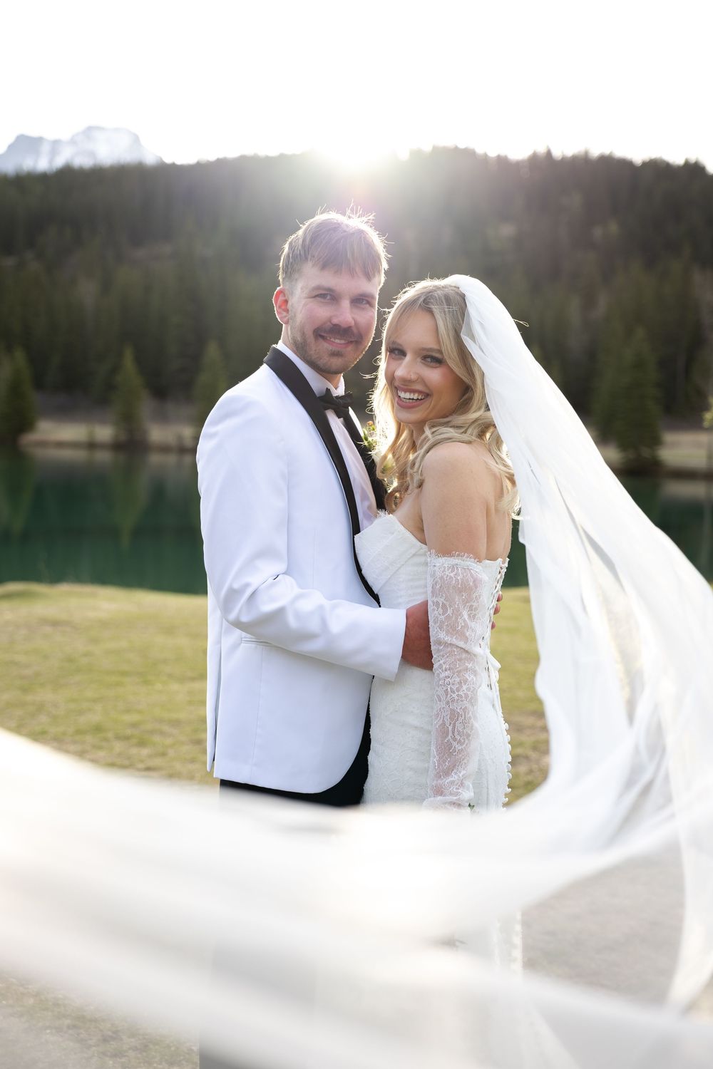 A romantic wedding photoshoot sequence of a couple in a field at sunset with a flowing white veil.