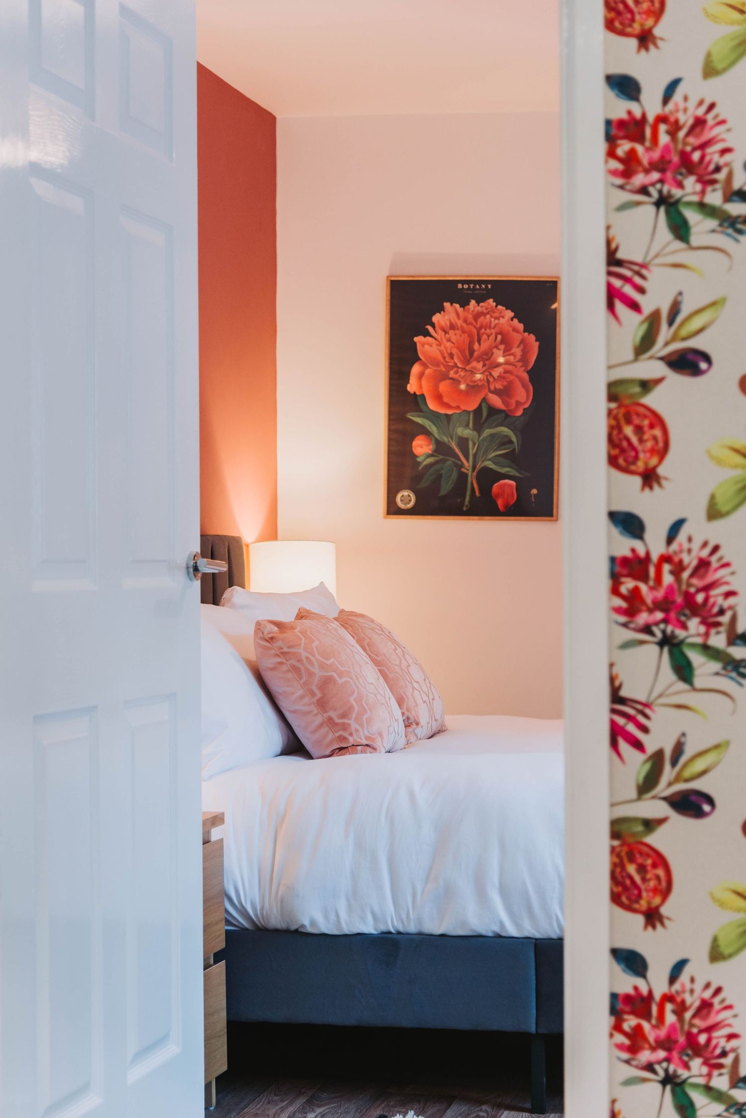 Bedroom view through a doorway, featuring warm tones and a gorgeous interior design, with a framed image in the background