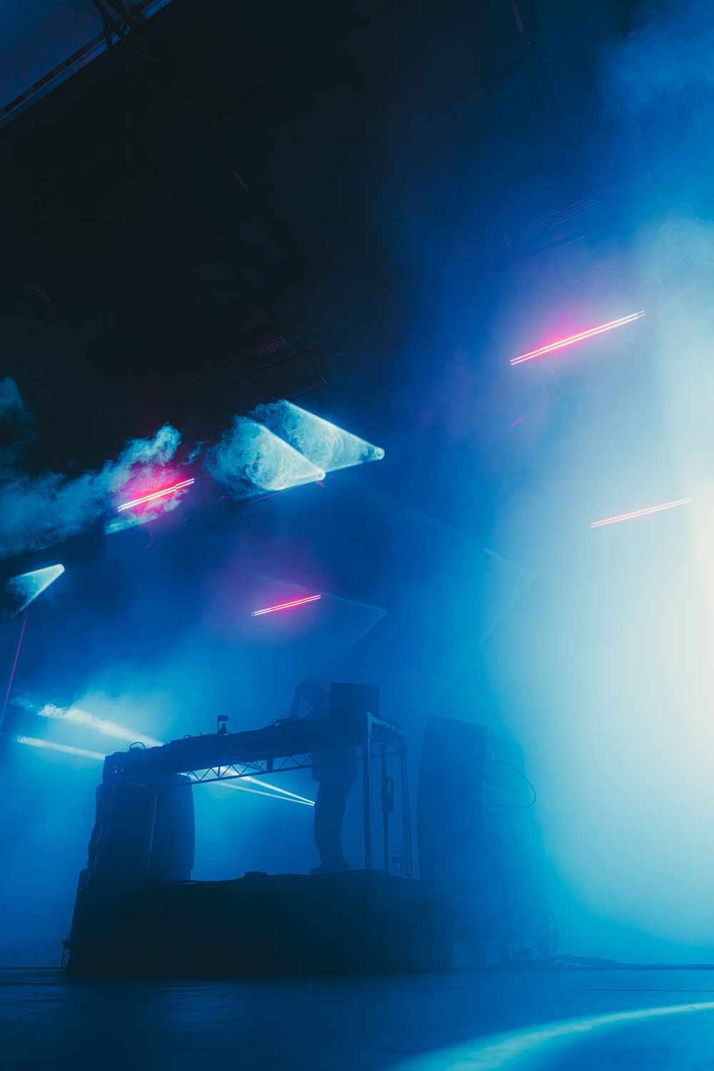 Futuristic sci-fi scene with glowing neon lights and floating geometric shapes against a dark blue misty backdrop.