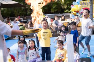 Families participating in fun outdoor activities at a summer festival with colorful decorations.在裝飾一新的夏日節日上，一家人正在參加有趣的戶外活動。