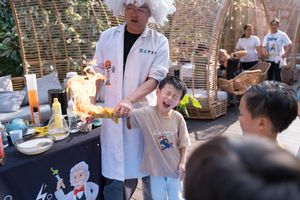 A chef at a food station serves customers during an outdoor catering event with drinks and dishes on display在戶外餐飲活動中，一位廚師在食品攤位為顧客提供飲料和菜餚。