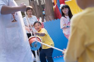 People in colorful clothing participate in a group activity or workshop in a bright indoor space.身著色彩鮮豔服裝的人們在明亮的室內空間參加團體活動或研討會。