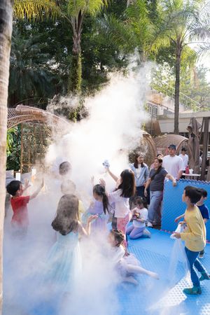 Group celebration with colorful powder smoke bombs on blue flooring outdoors.在戶外藍色地板上，人們用彩色粉末煙霧彈進行集體慶祝活動。