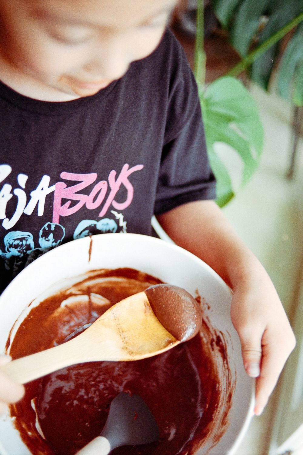 A series of photos showing melted chocolate being stirred in a glass mixing bowl.