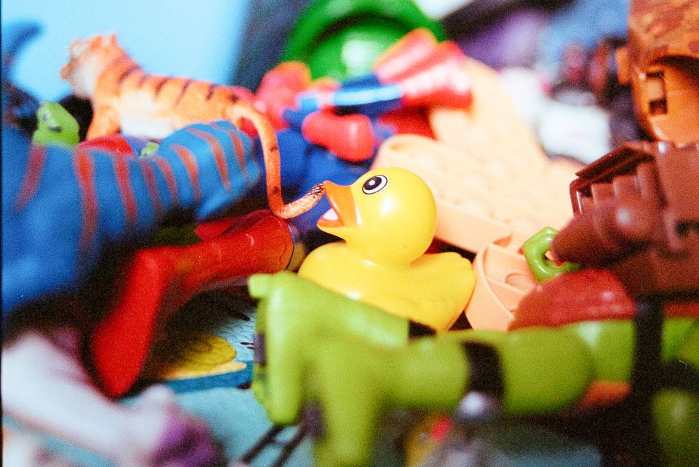 Close-up of colorful plastic toys including a yellow rubber duck among other assorted playthings.