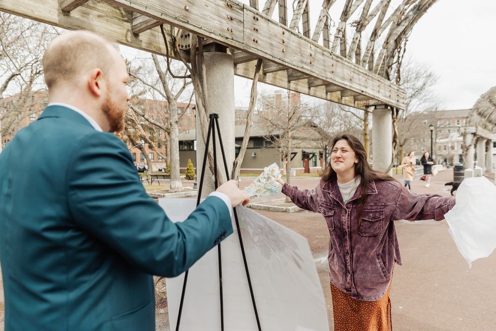 Couple sharing a joyful outdoor moment near an urban structure, woman spreading arms wide in happiness.