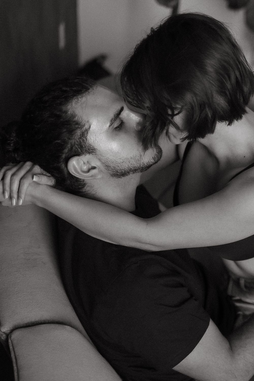 Black and white romantic photograph of a couple embracing in an intimate moment.