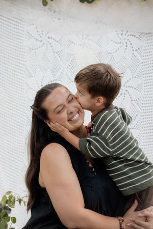 A tender moment of affection and laughter captured against a white lace backdrop.