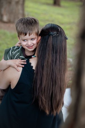 Playful outdoor portrait session showing joyful interaction between parent and child.