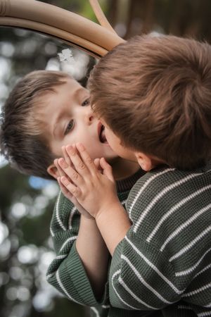 Close-up outdoor portraits showing playful expressions and green striped sweater.