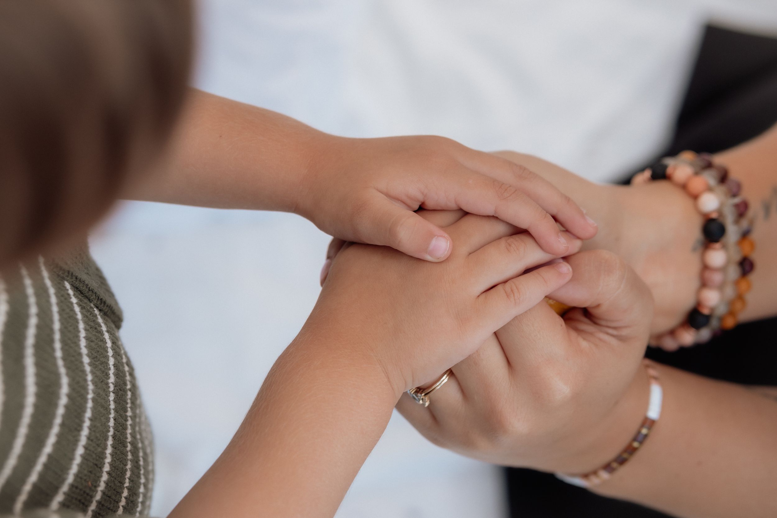Close-up of hands with bracelets reaching and connecting in an artistic composition.