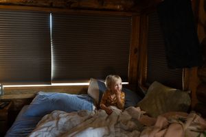 A dimly lit interior room with sunlight streaming through window blinds.