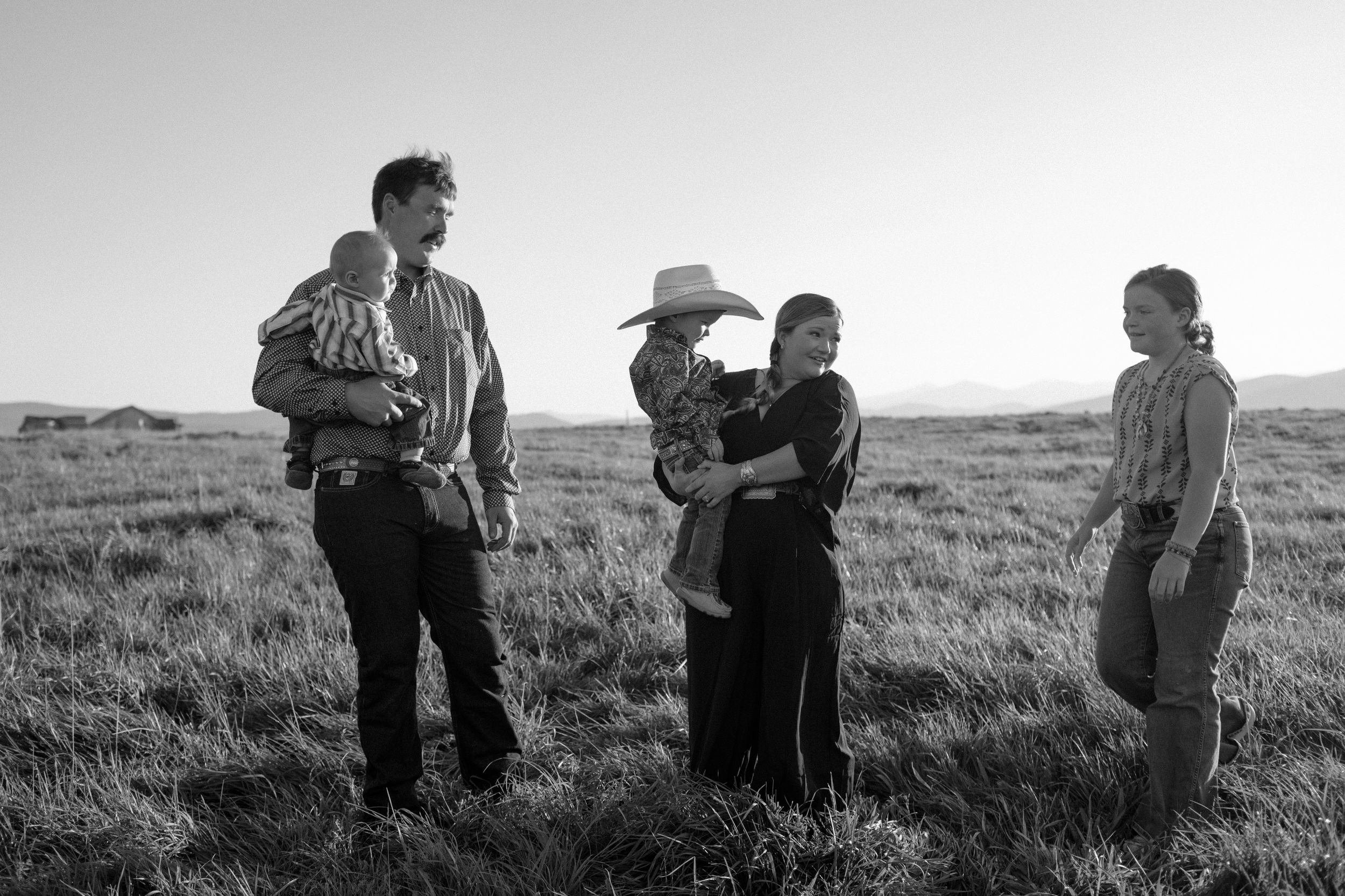Group gathered in conversation at sunset in an open field.