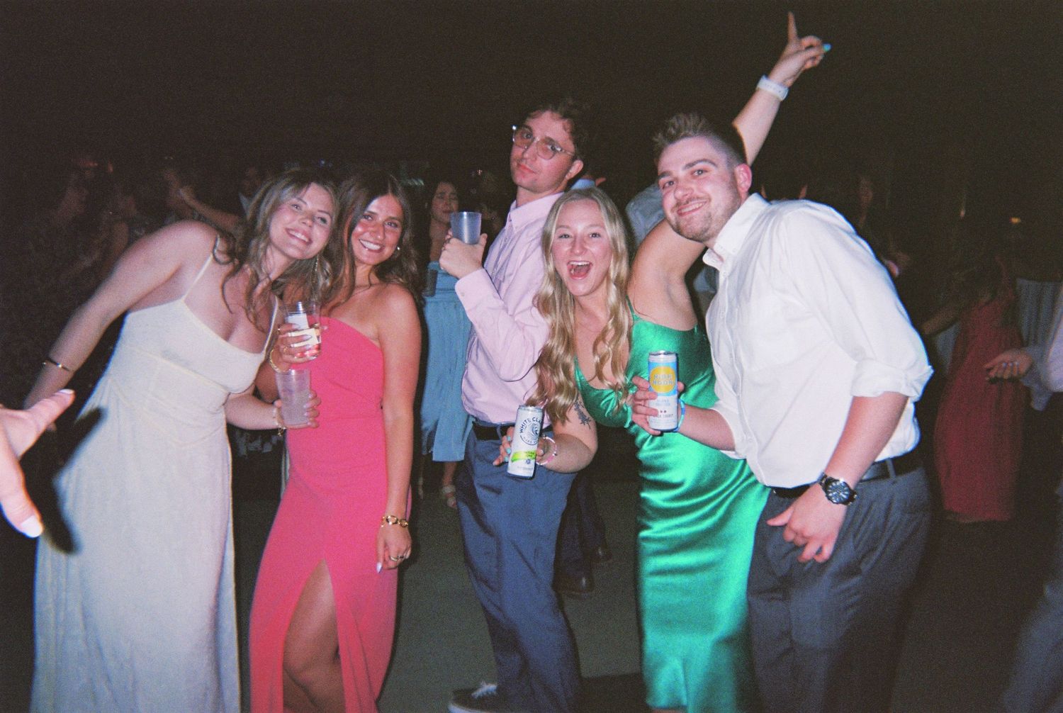 A group of people dancing and celebrating together at a nighttime party event.