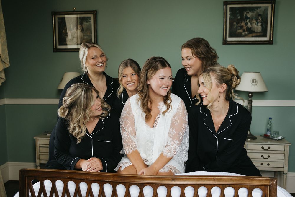 Wedding party gathering in a room with mint green walls and vintage decor.