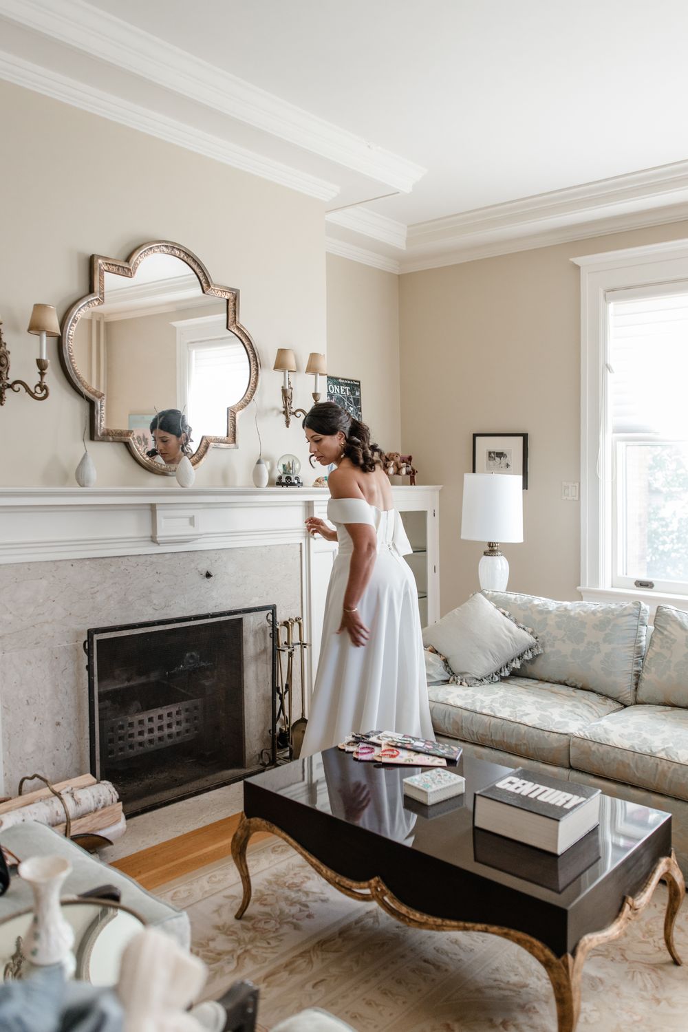 Elegant living room interior with white walls, fireplace, and decorative mirror showcasing modern transitional style.